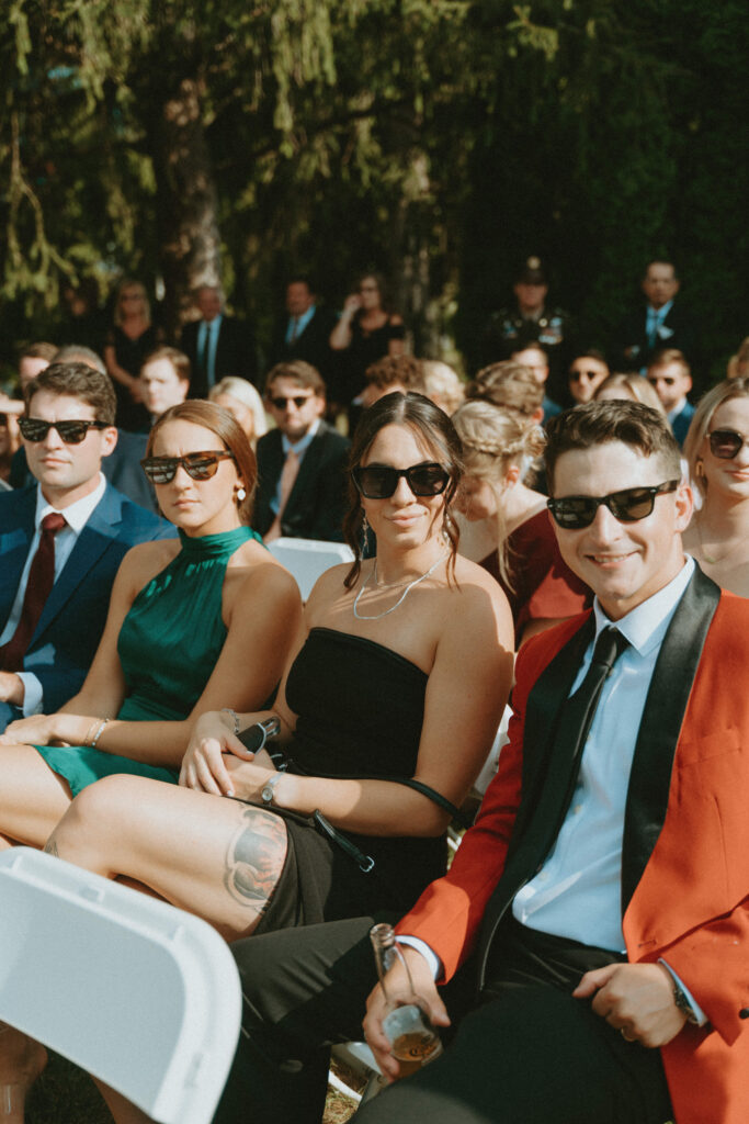 Summer wedding guests dressed to the nines with sunglasses