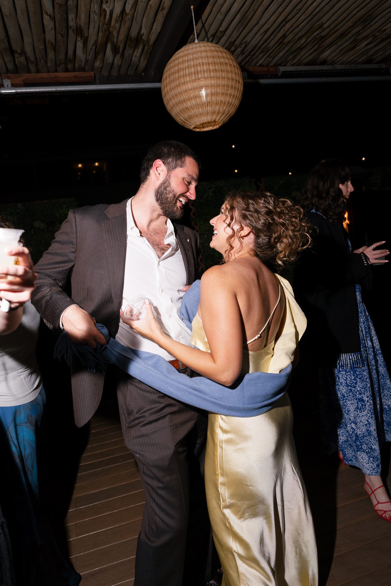 wedding guests dancing on the dance floor and smiling. 