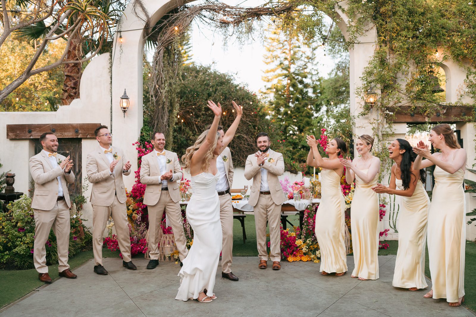 newlyweds sharing their first dance surrounded by their wedding party. 