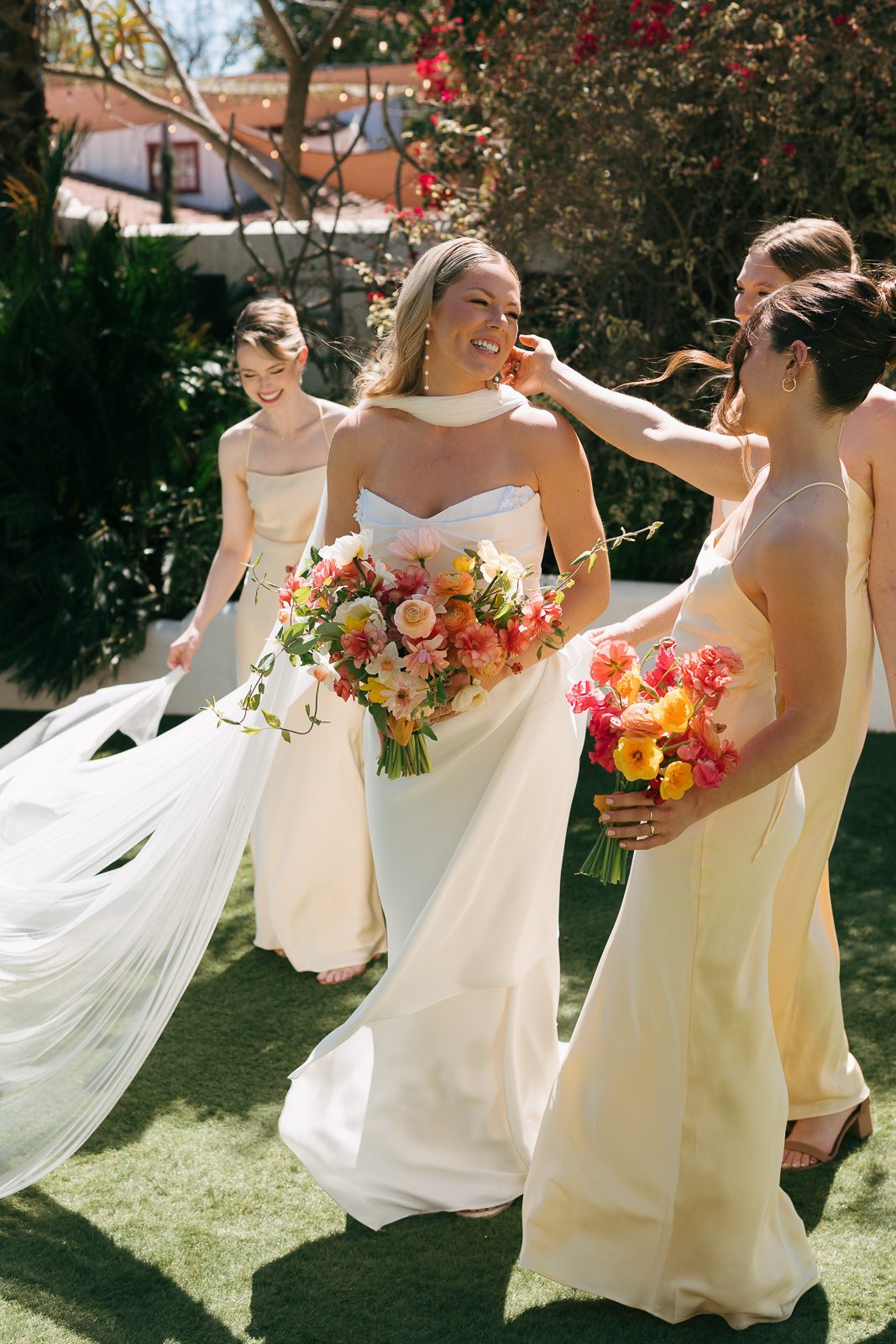 the bride and her bridesmaids smiling while walking on the Tivoli Italian Villa courtyard. 