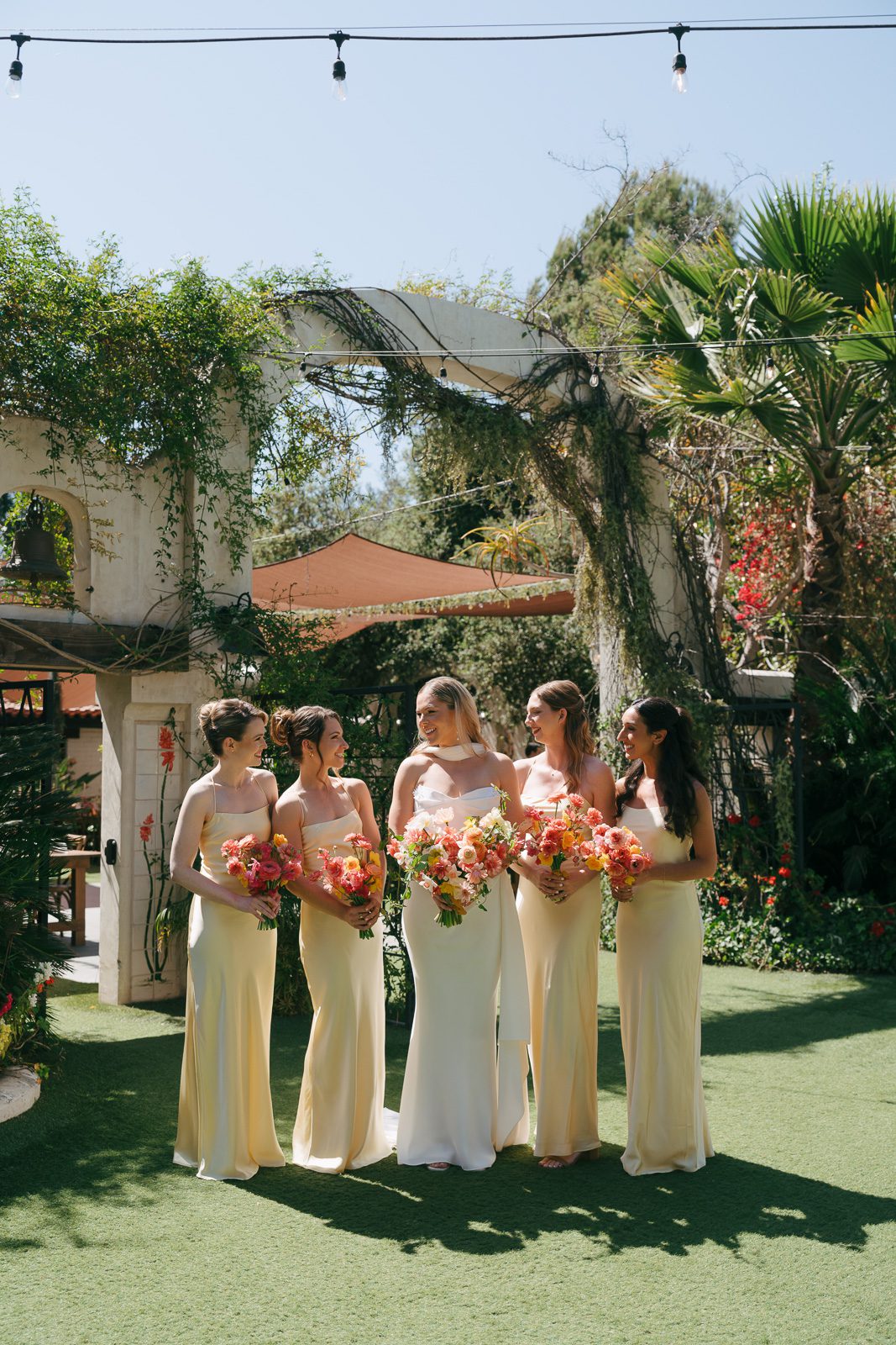 bride and her bridesmaids smiling in the Tivoli Italian Villa wedding courtyard. 