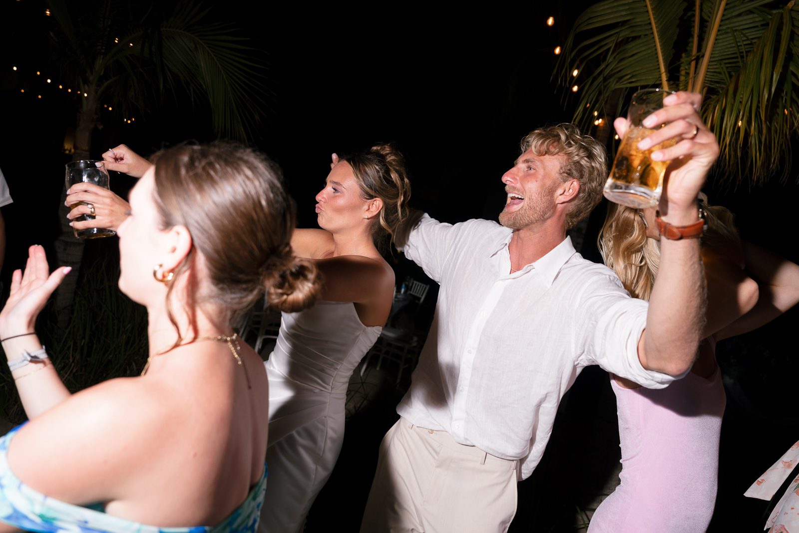 A couple dancing, drinking, and having a good time on the dance floor. 