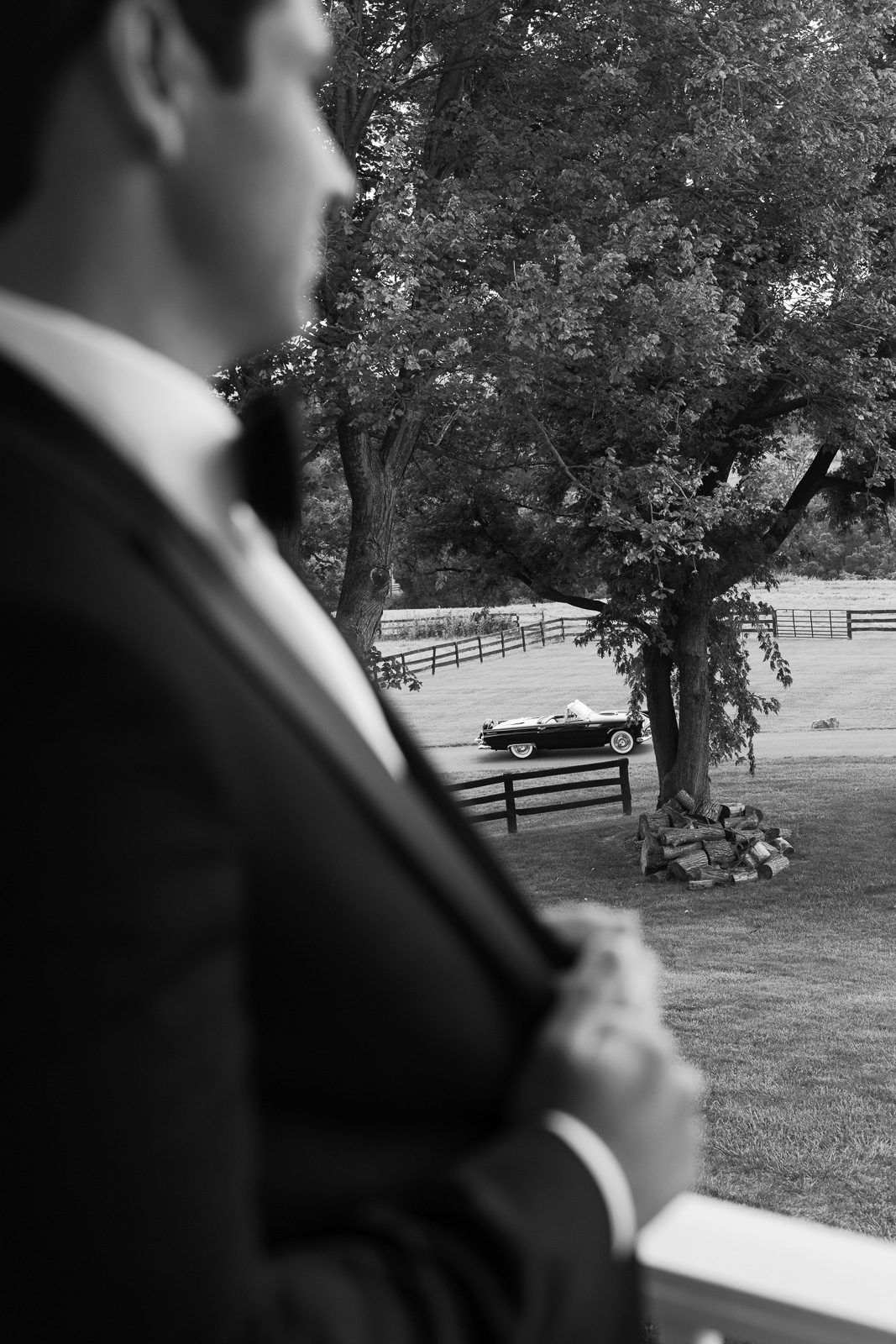 the groom blurred out with trees and the thunderbird in the distance. 