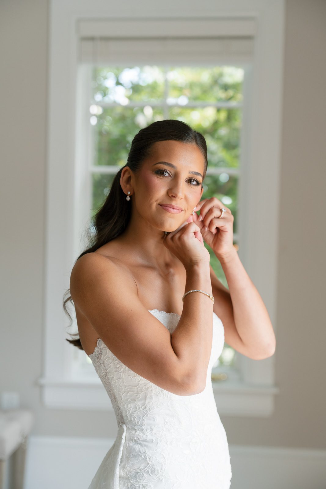 the bride putting on an earring during her The View At Bluemont wedding