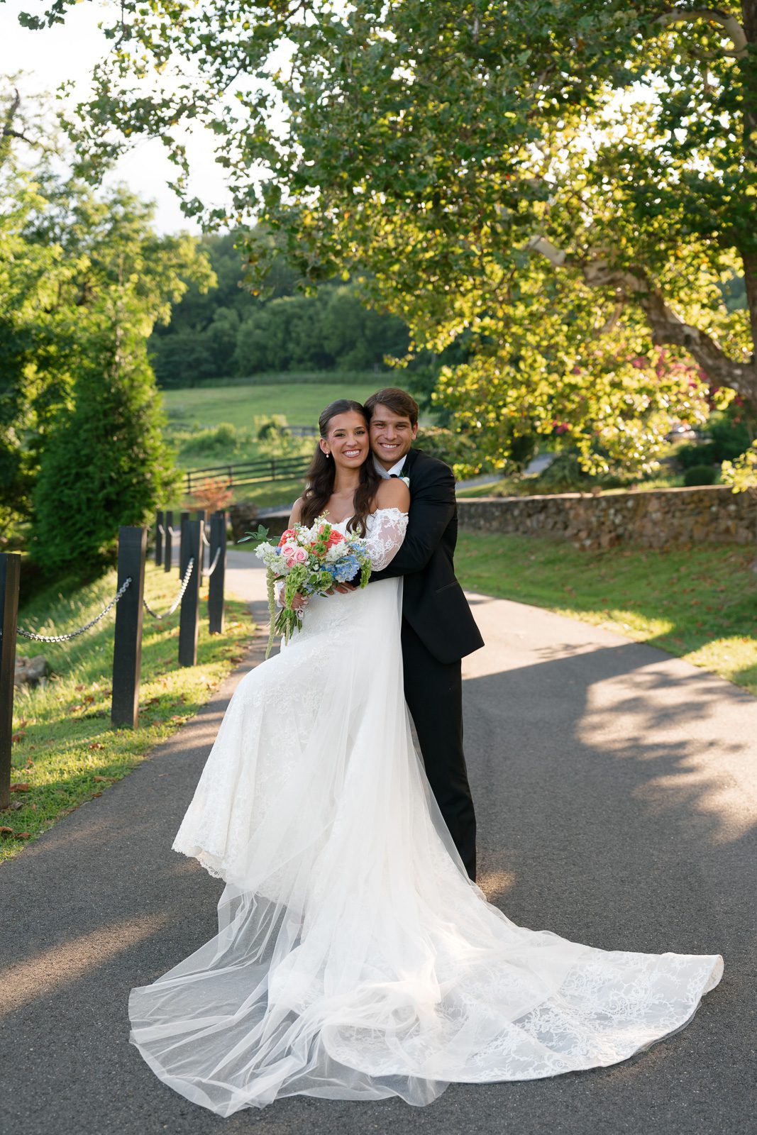 newlyweds hugging on a country road during their The View At Bluemont wedding