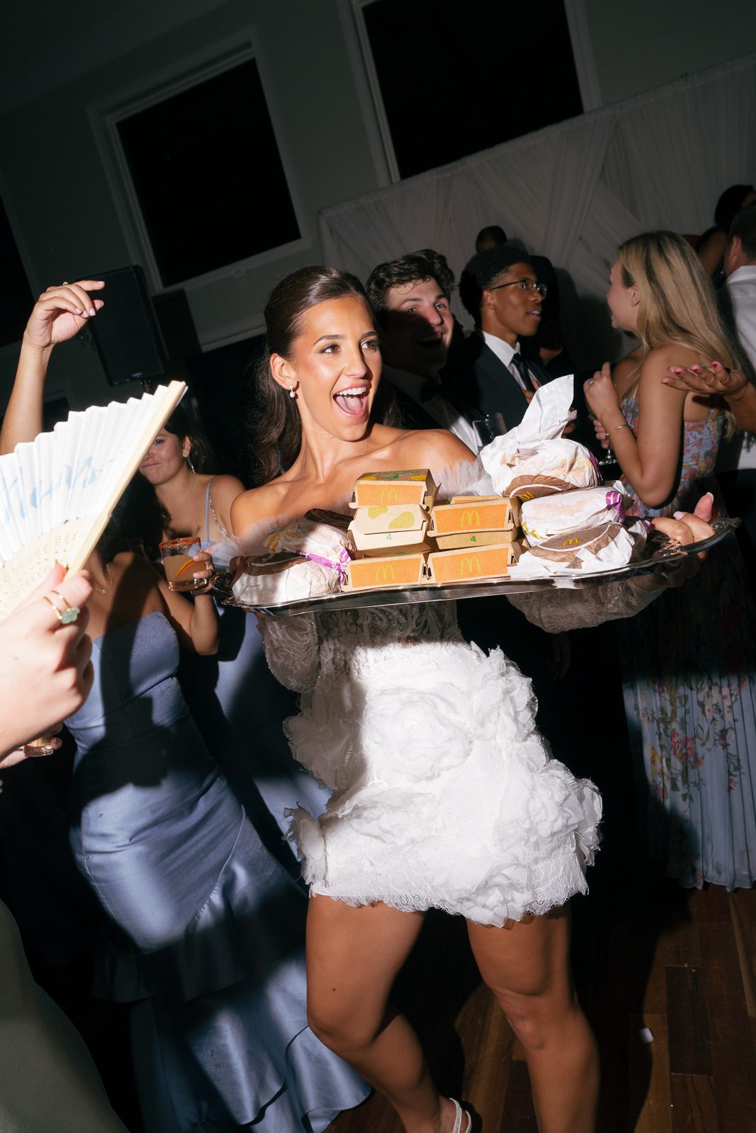 the bride bringing in mcdonalds for wedding guests partying on the dance floor. 