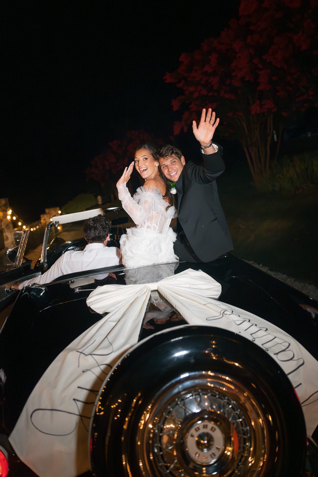 newlyweds driving off in their grandpa's thunderbird during their The View At Bluemont wedding. 