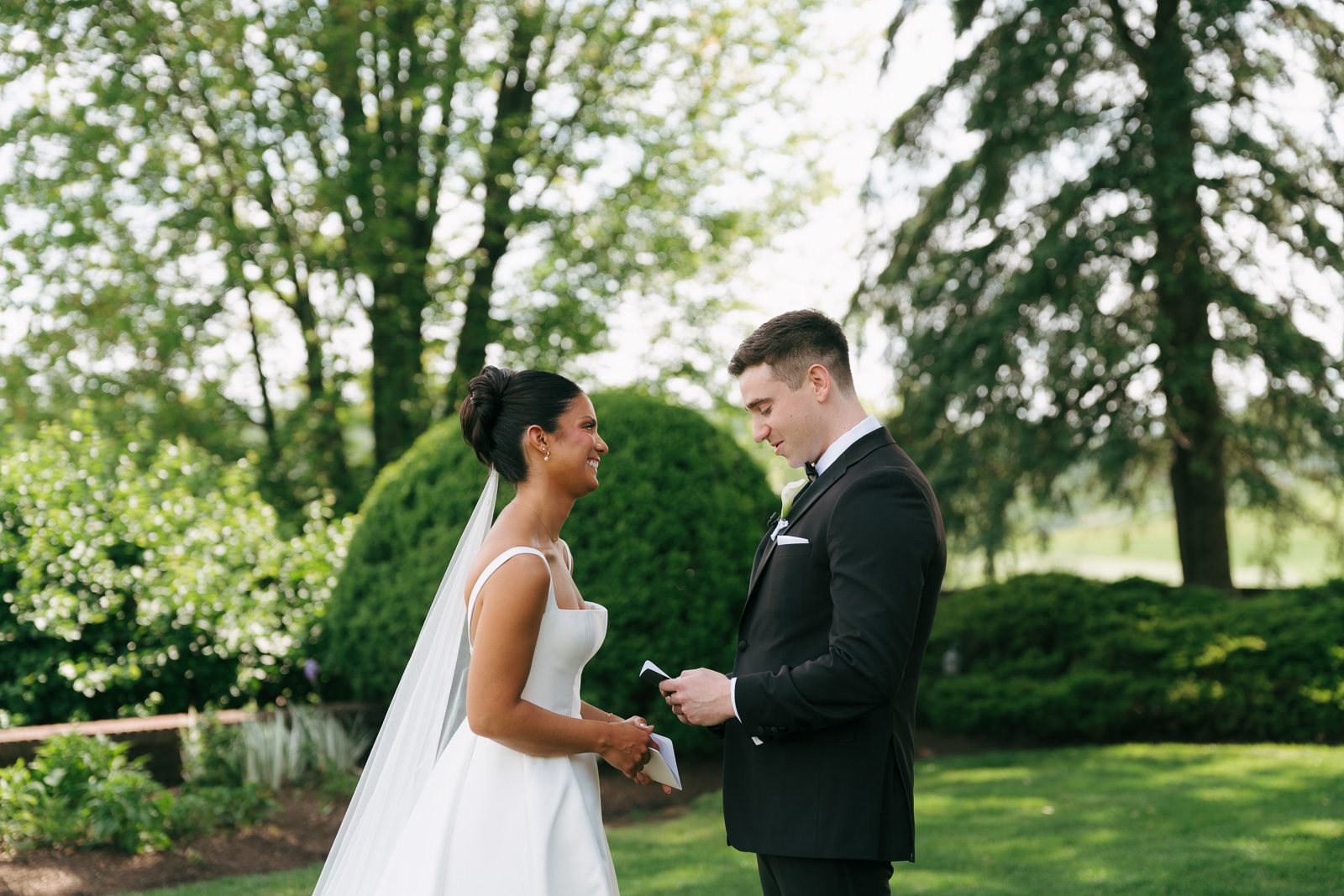newlyweds exchanging vows on a grassy lawn as part of their wedding day timeline. 