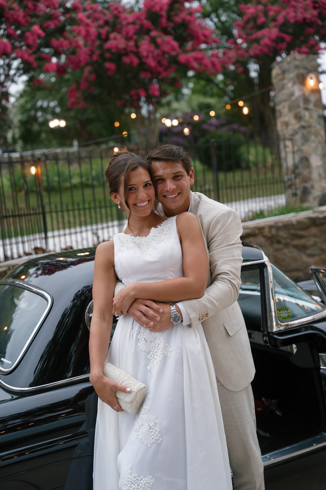 newlyweds hugging in front of their grandpa's thunderbird during their The View At Bluemont wedding