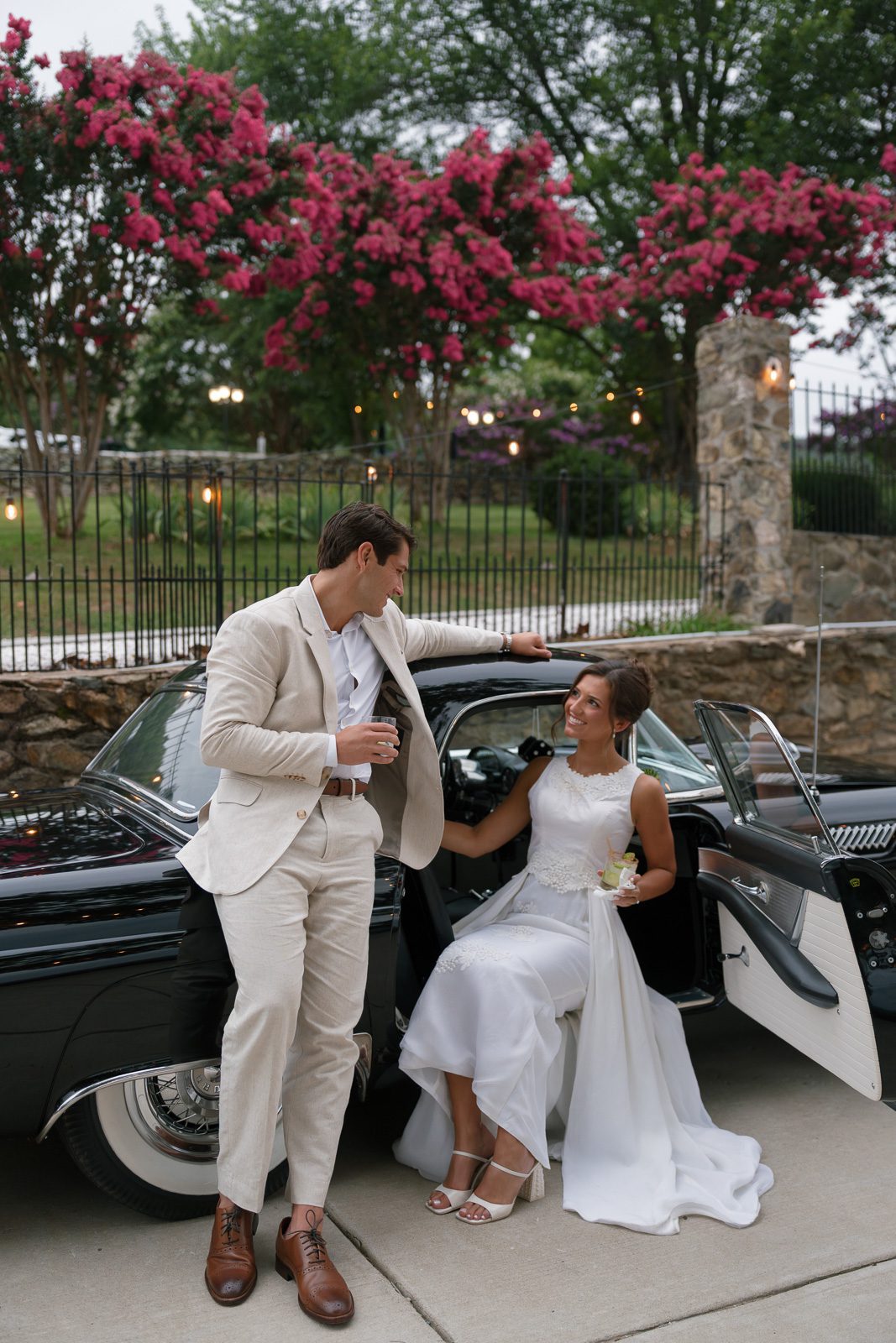 newlyweds smiling and sitting on a Thunderbird during their The View At Bluemont wedding