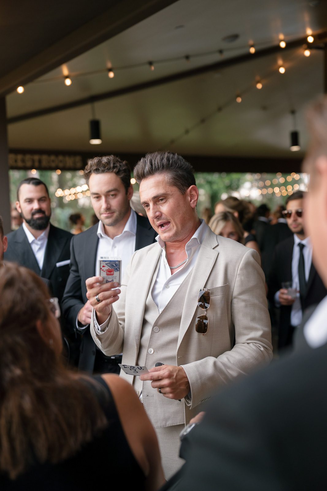 a magician entertaining guests during cocktail hour, a way to make your wedding unique.
