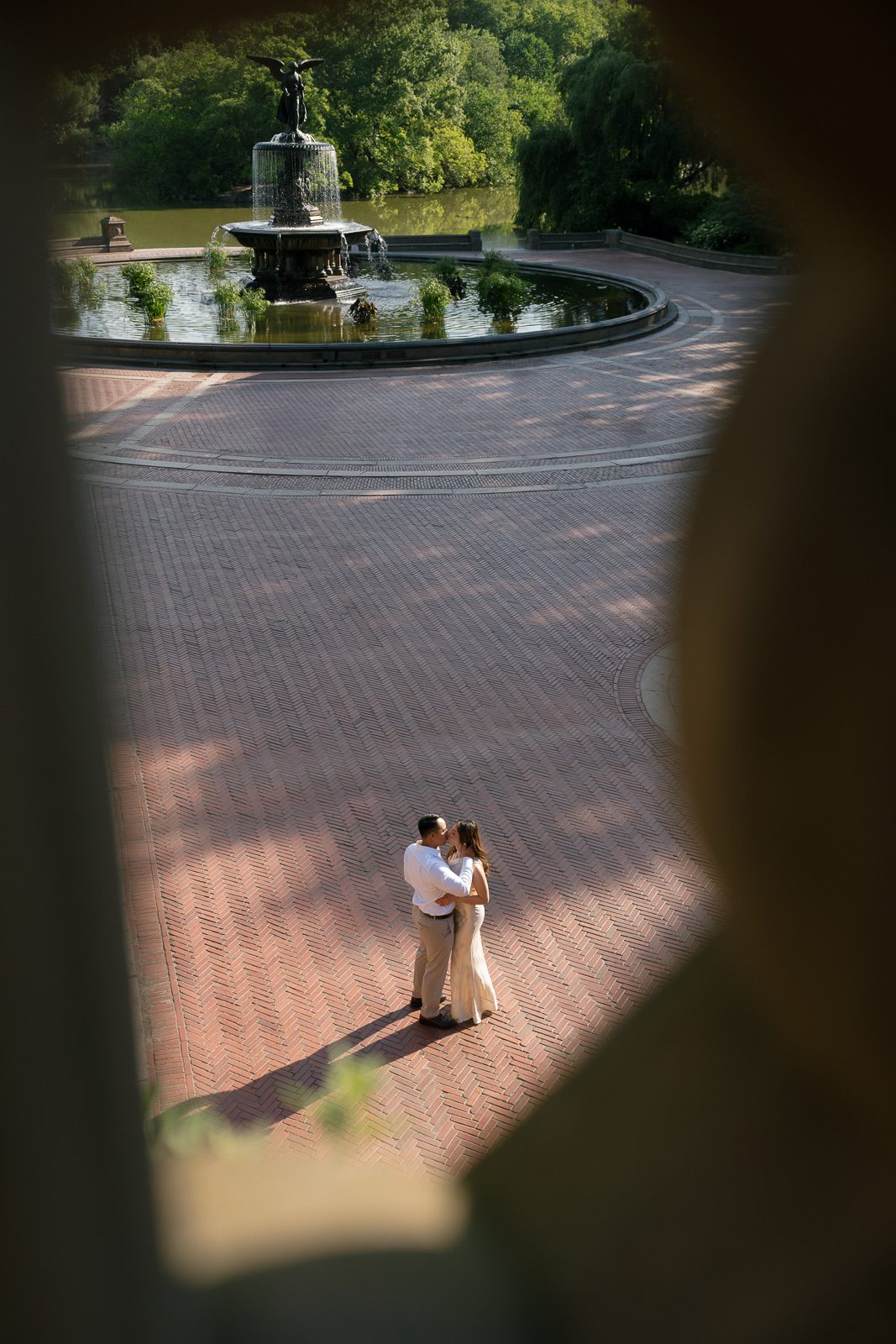 couple kissing by bethesda fountain during their NYC engagement photos. 