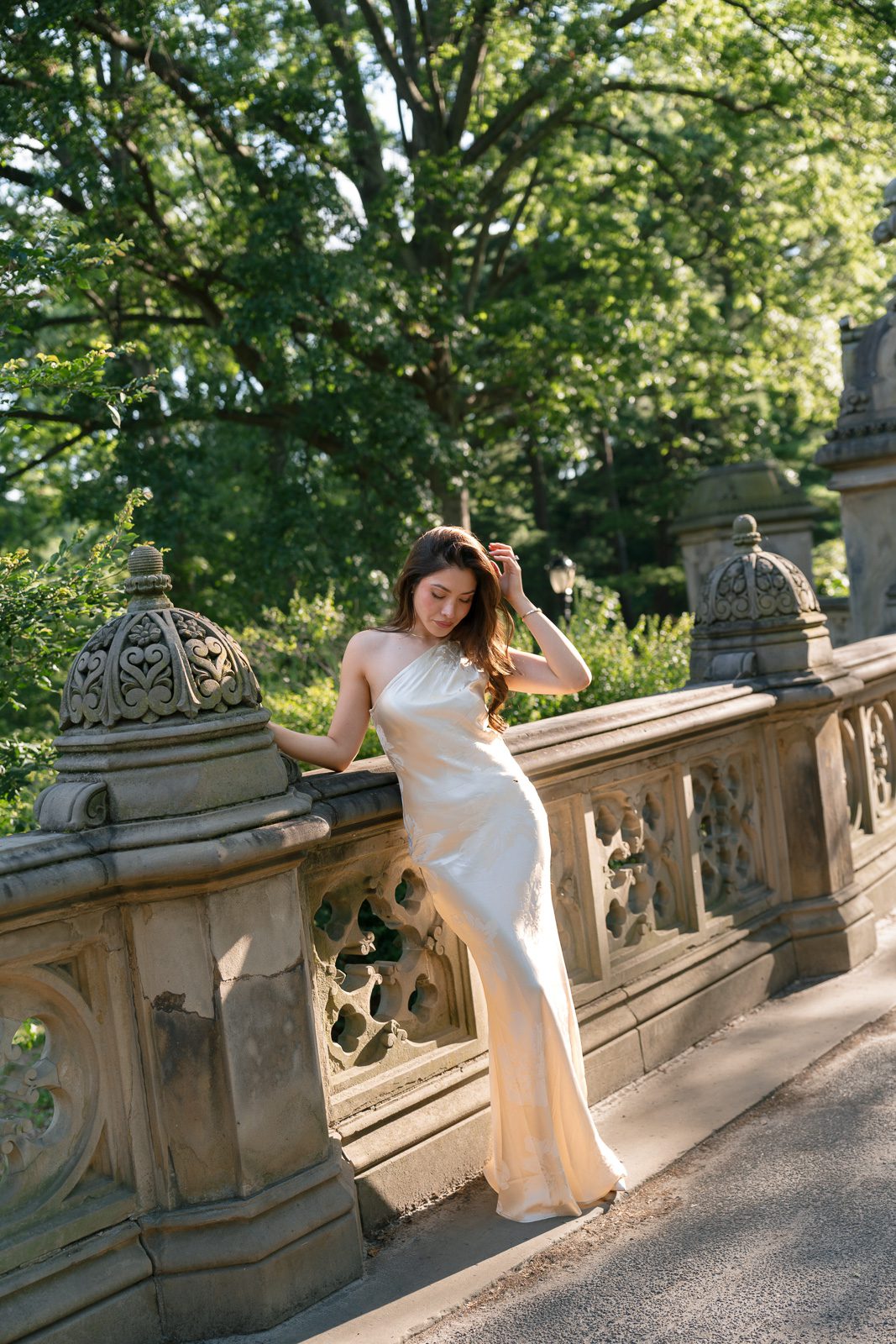 girlfriend posing in front of a stone wall in central park. 