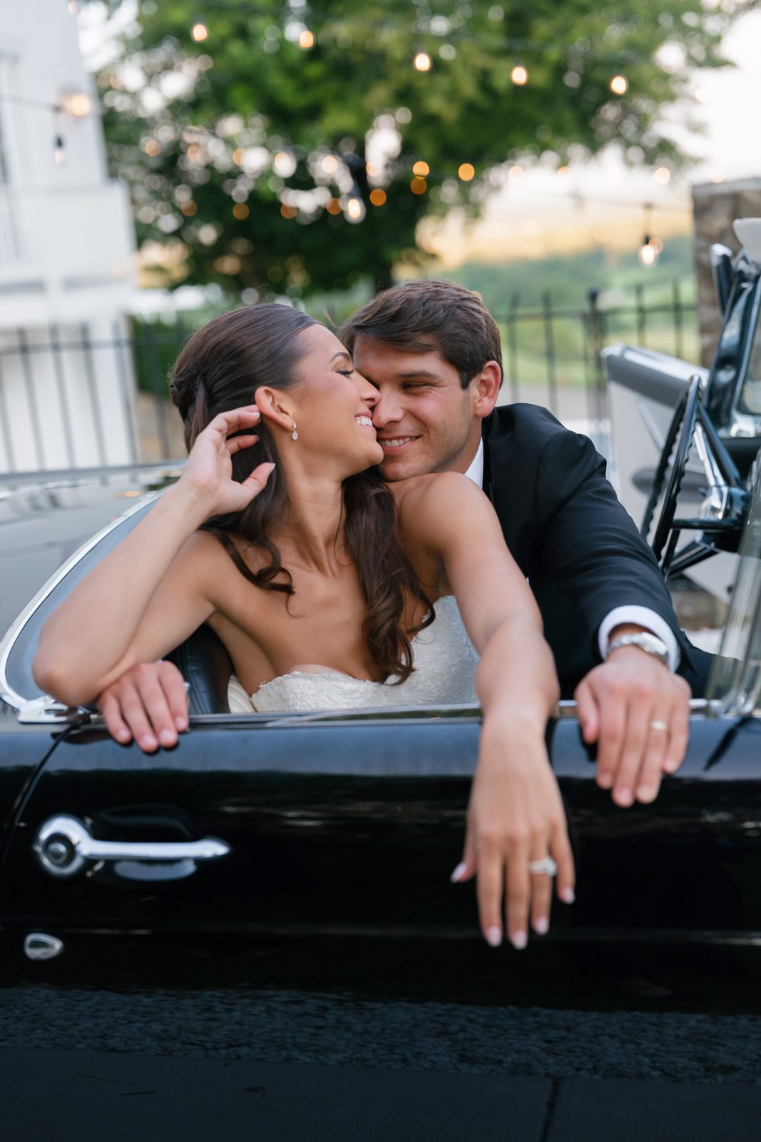 newlyweds smiling inside of a vintage car, something that makes their wedding unique.