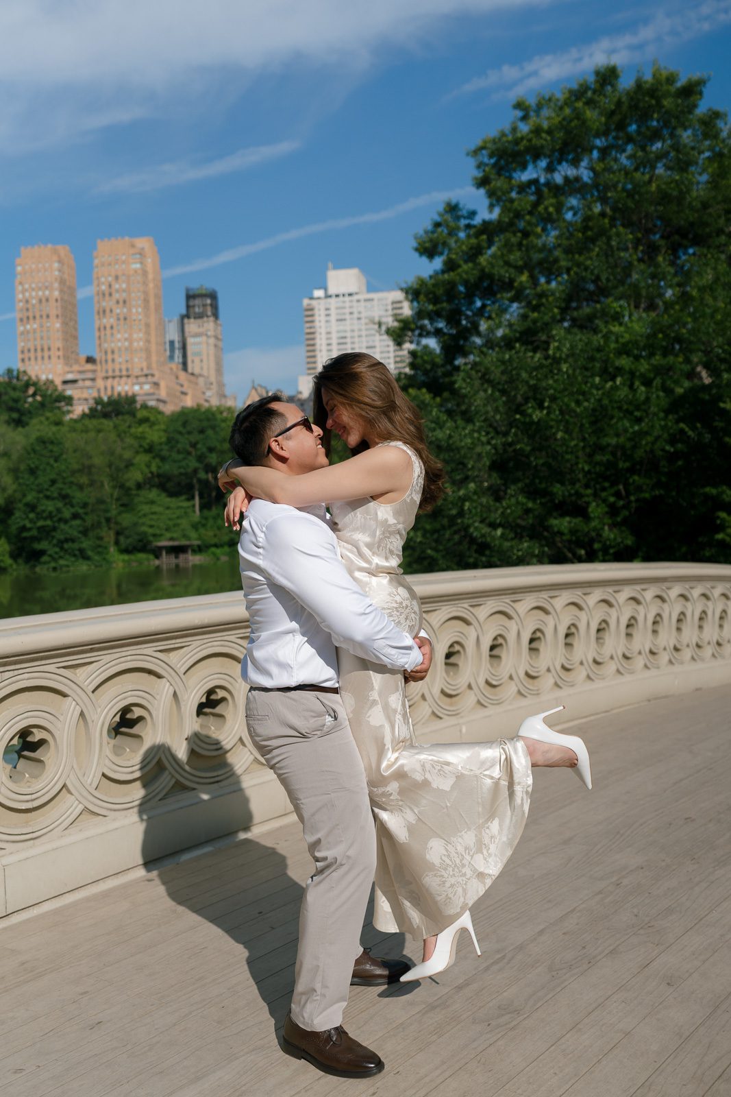couple hugging on a bridge in central park. 