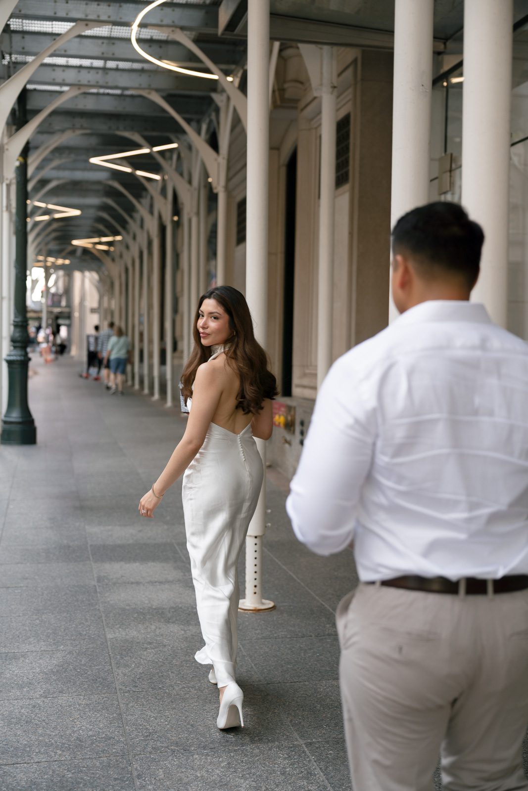 couple walking down a new york sidewalk during their NYC engagement photos. 
